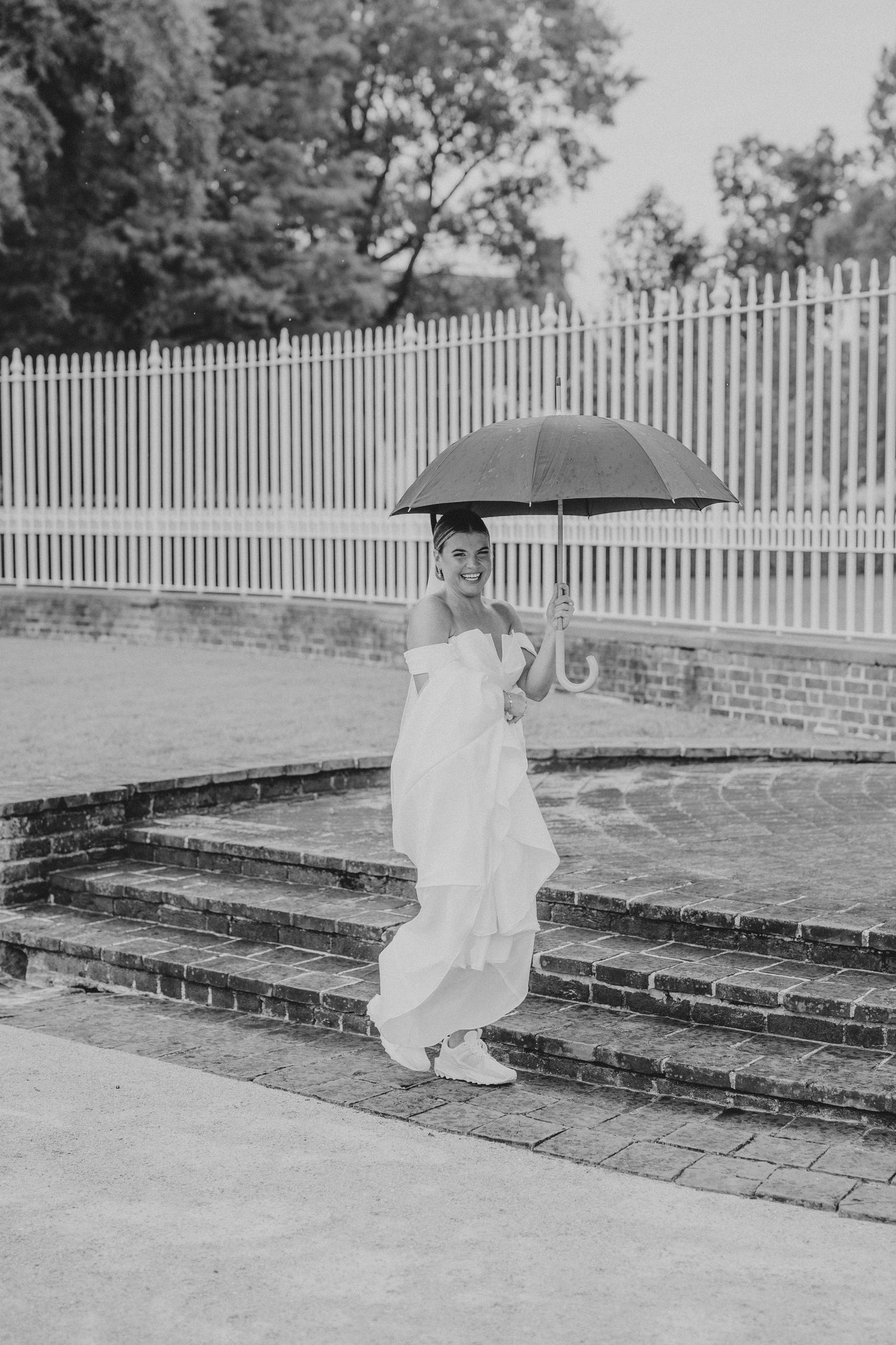 A sequence of black and white photos showing someone walking up brick steps in front of a white picket fence.