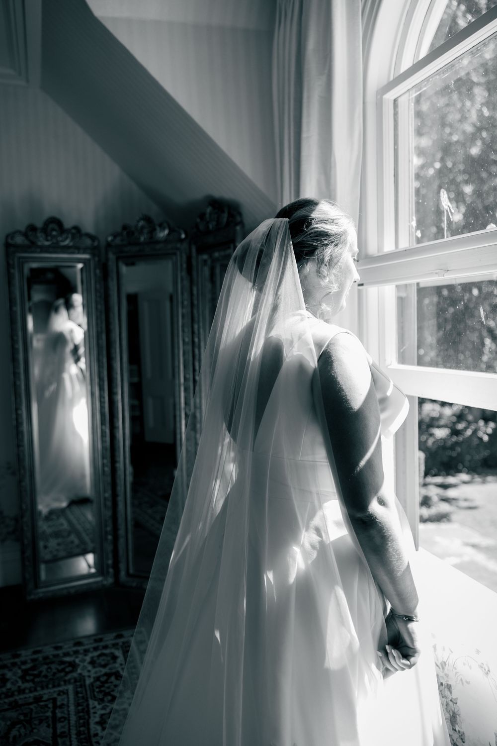A series of black and white photos showing a wedding dress by a window with dramatic light and shadows.