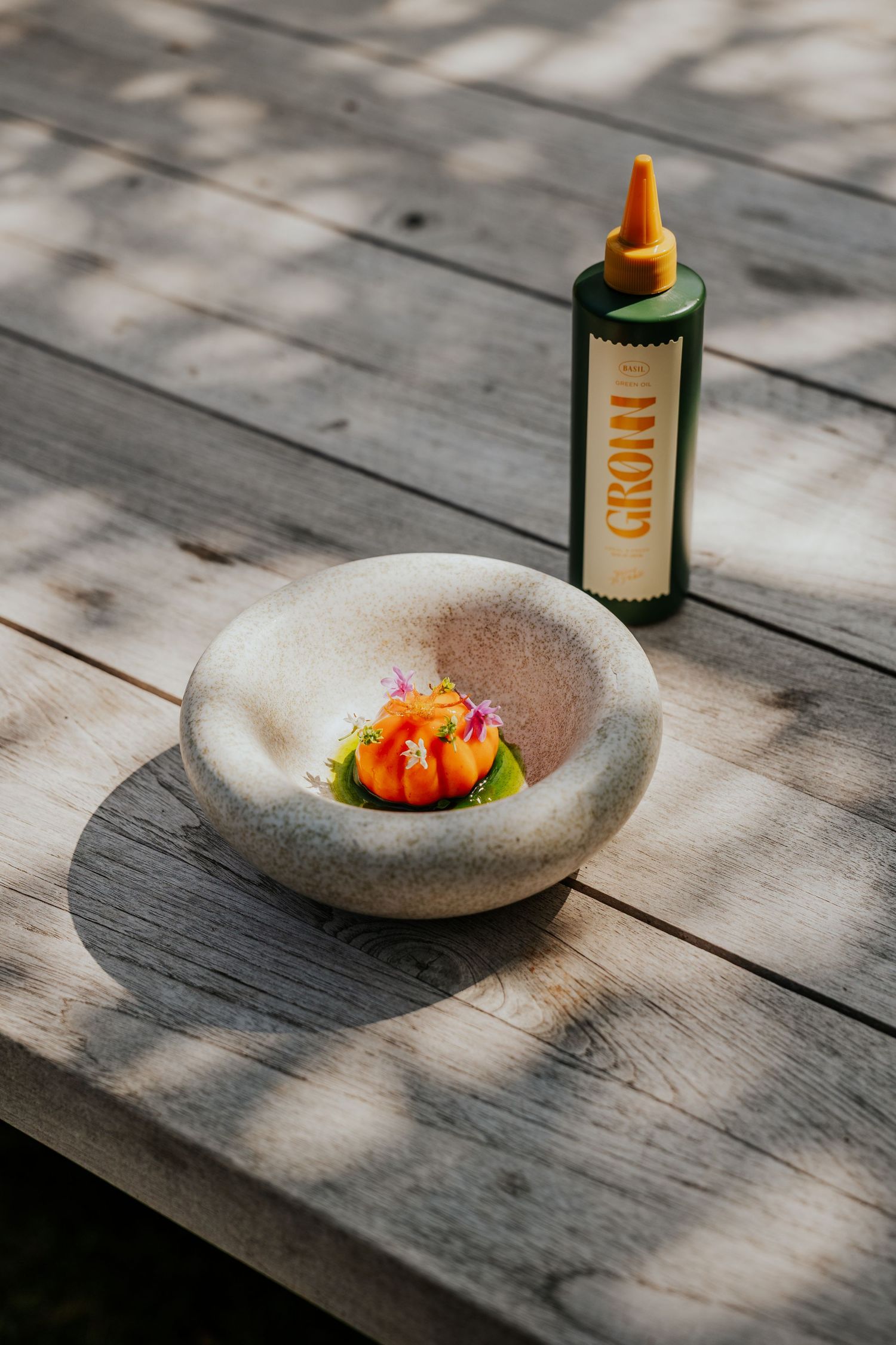 Stone bowl and decorative bottles arranged on weathered wooden surface.
