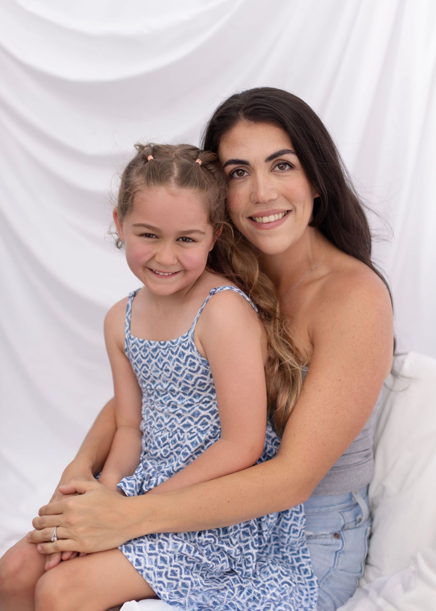 Two people wearing complementary blue and gray outfits pose together against a white backdrop in casual studio photos. Cloverdale Market Day