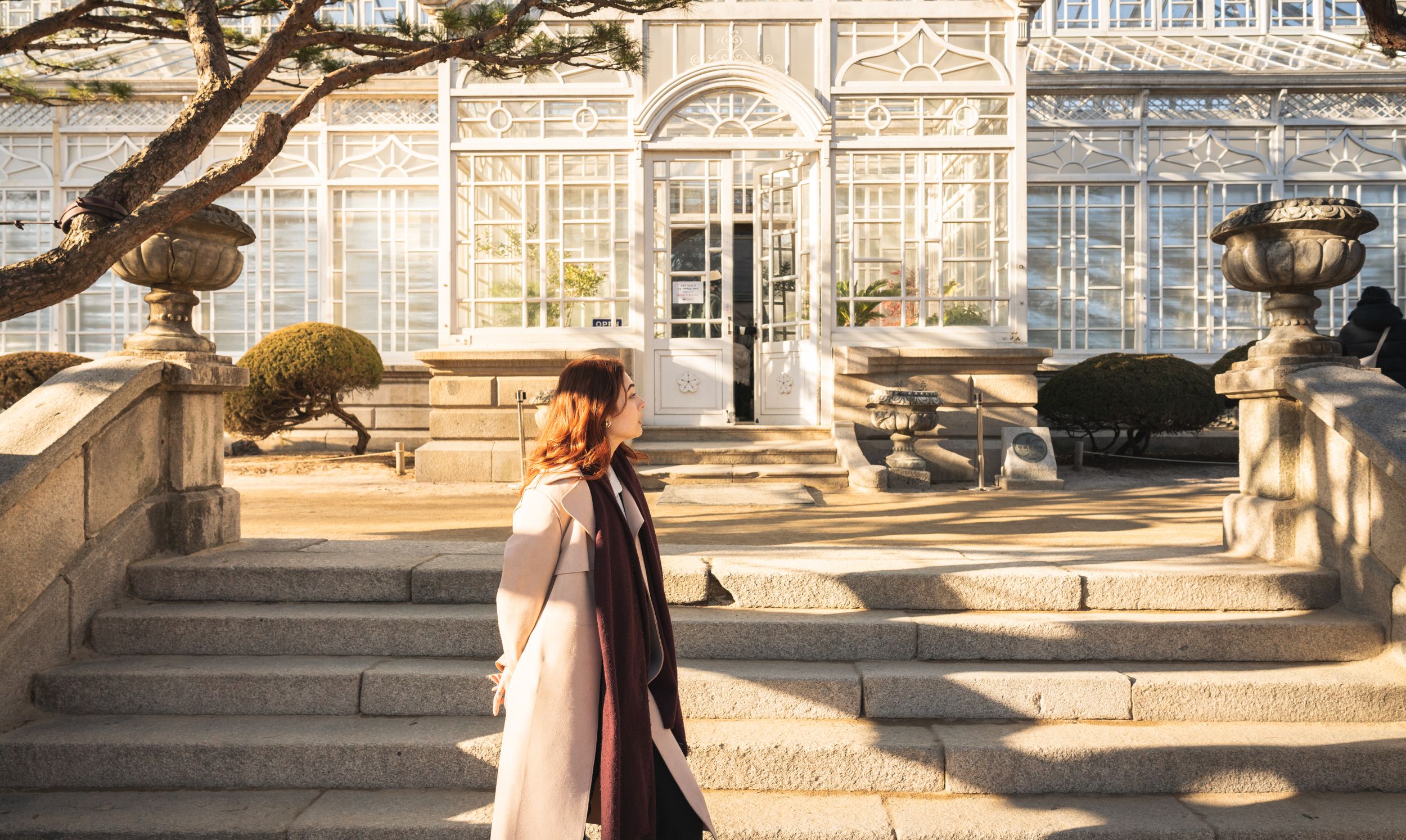 Stone pathways and traditional Korean architecture create a serene courtyard scene.