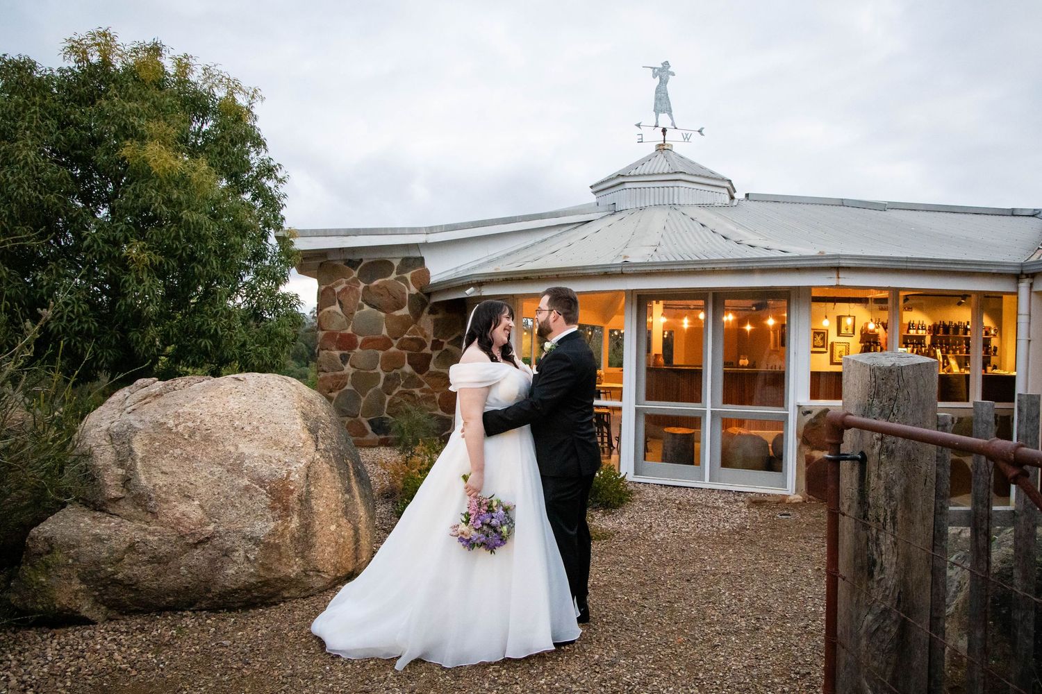 A romantic outdoor photoshoot in a lush garden landscape with warm sunset lighting and natural greenery.