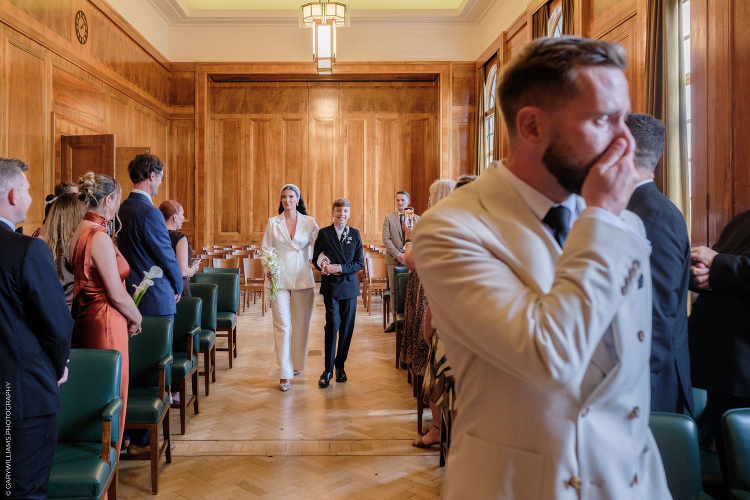 Creative wedding photo series showing couple peeking out from wooden doorway in minimal architectural setting.