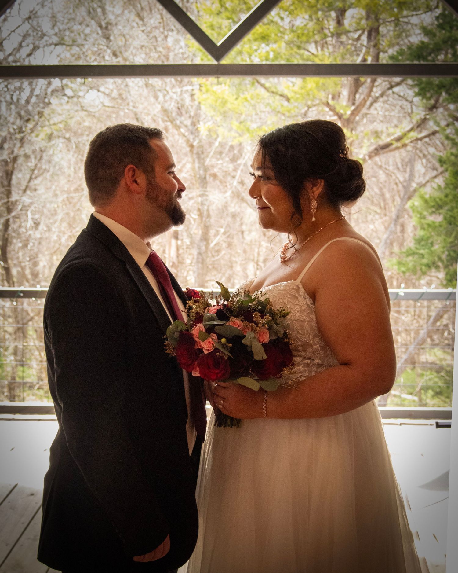 A couple shares an intimate first look moment before their wedding in an outdoor setting under natural light.