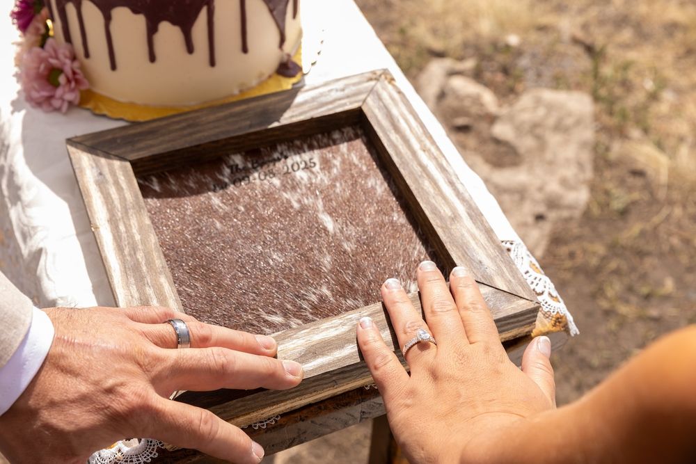 Hand assembling a wooden picture frame on a rustic surface.