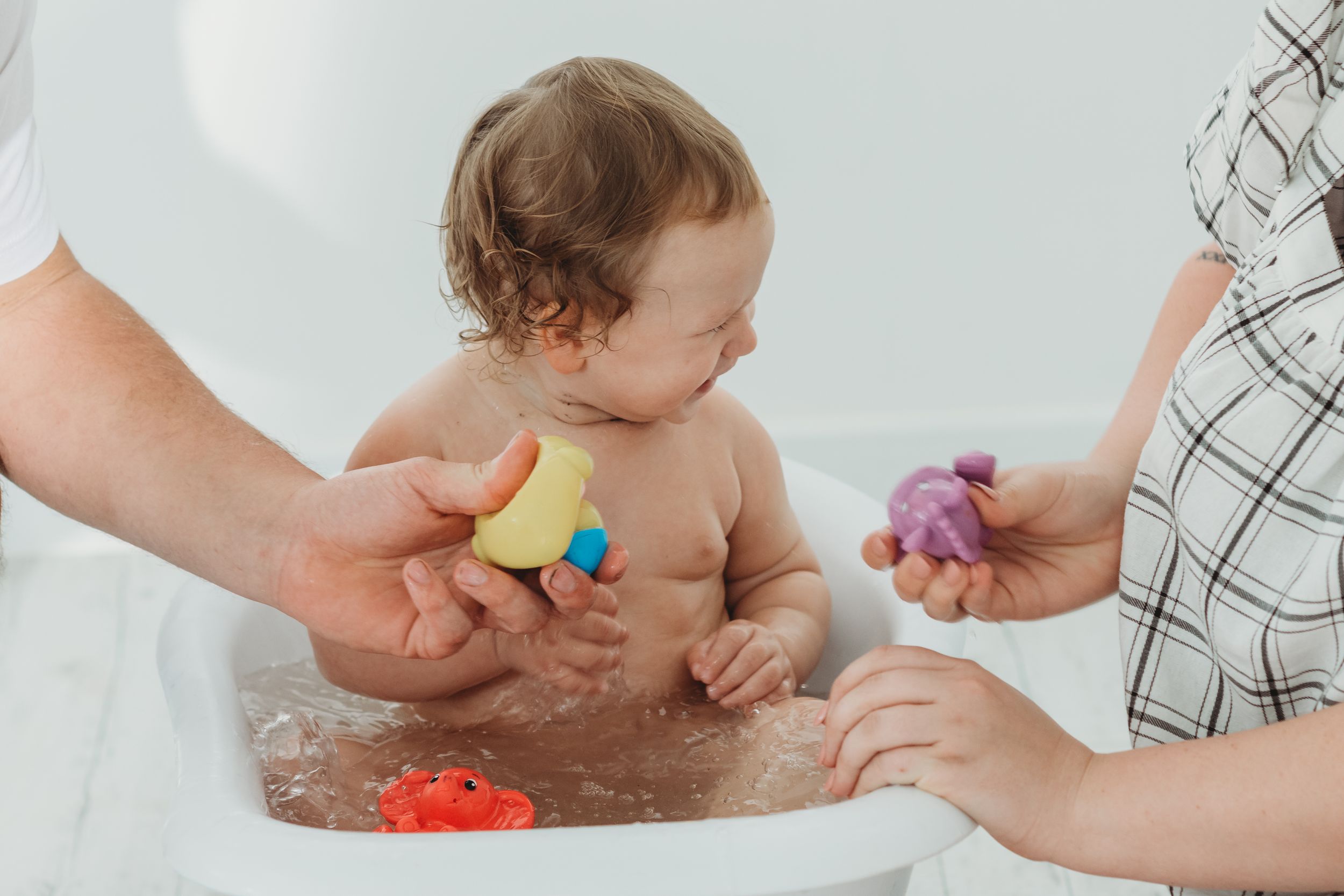 Bath time play with colorful toys and helping hands.