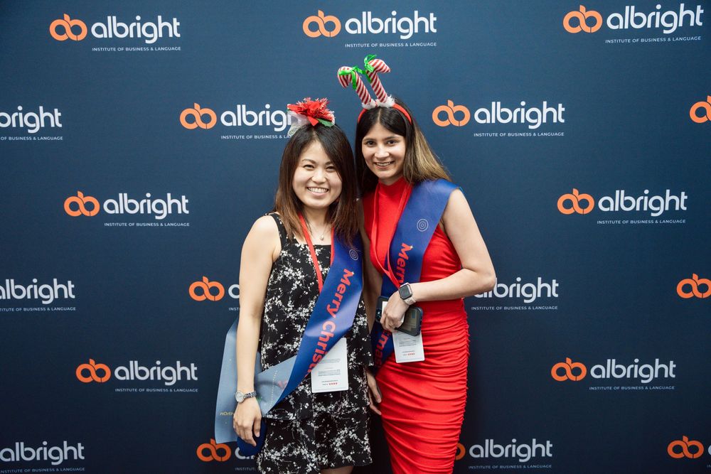 Attendees networking and posing at a professional tech conference with Albright branded backdrop displays.