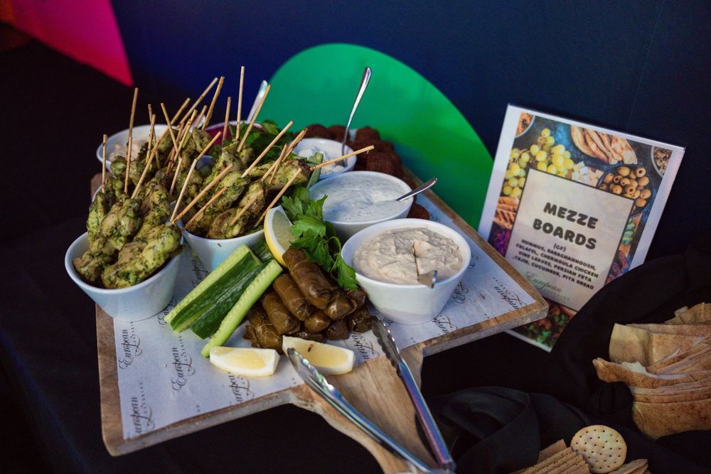 Diners share an assortment of appetizers and small plates at a dimly lit restaurant table.