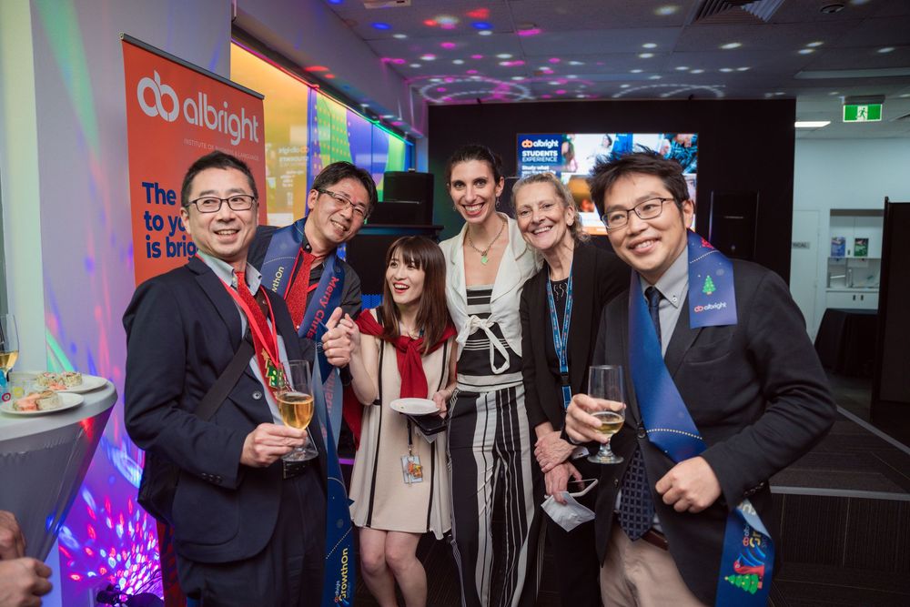 Business professionals socializing at a colorful corporate event with blue and purple lighting effects.