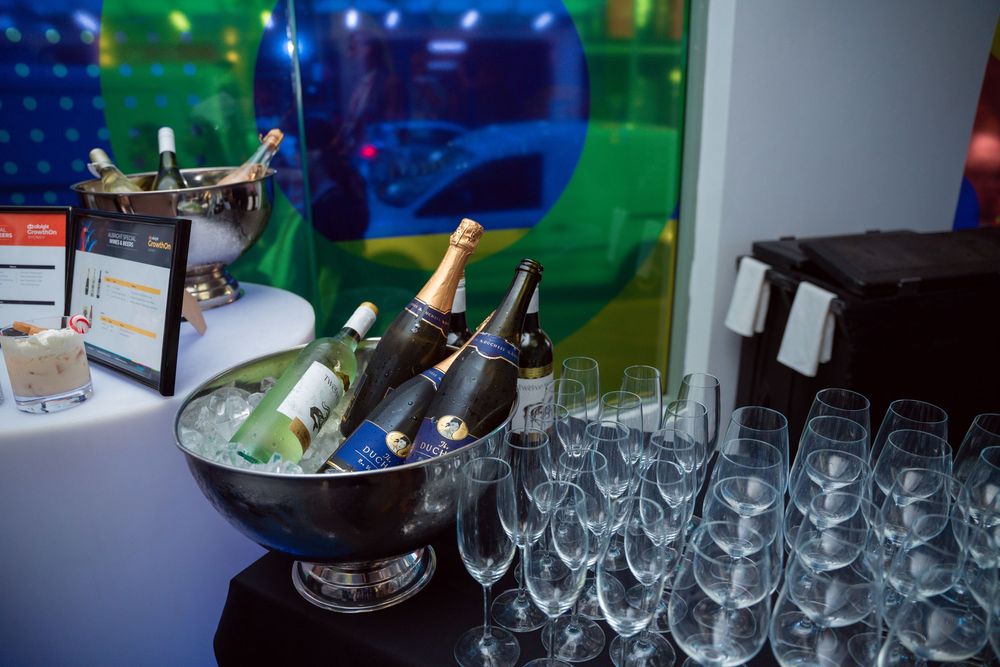 Champagne bottles chilling in ice bucket with empty glasses set up for a celebration.