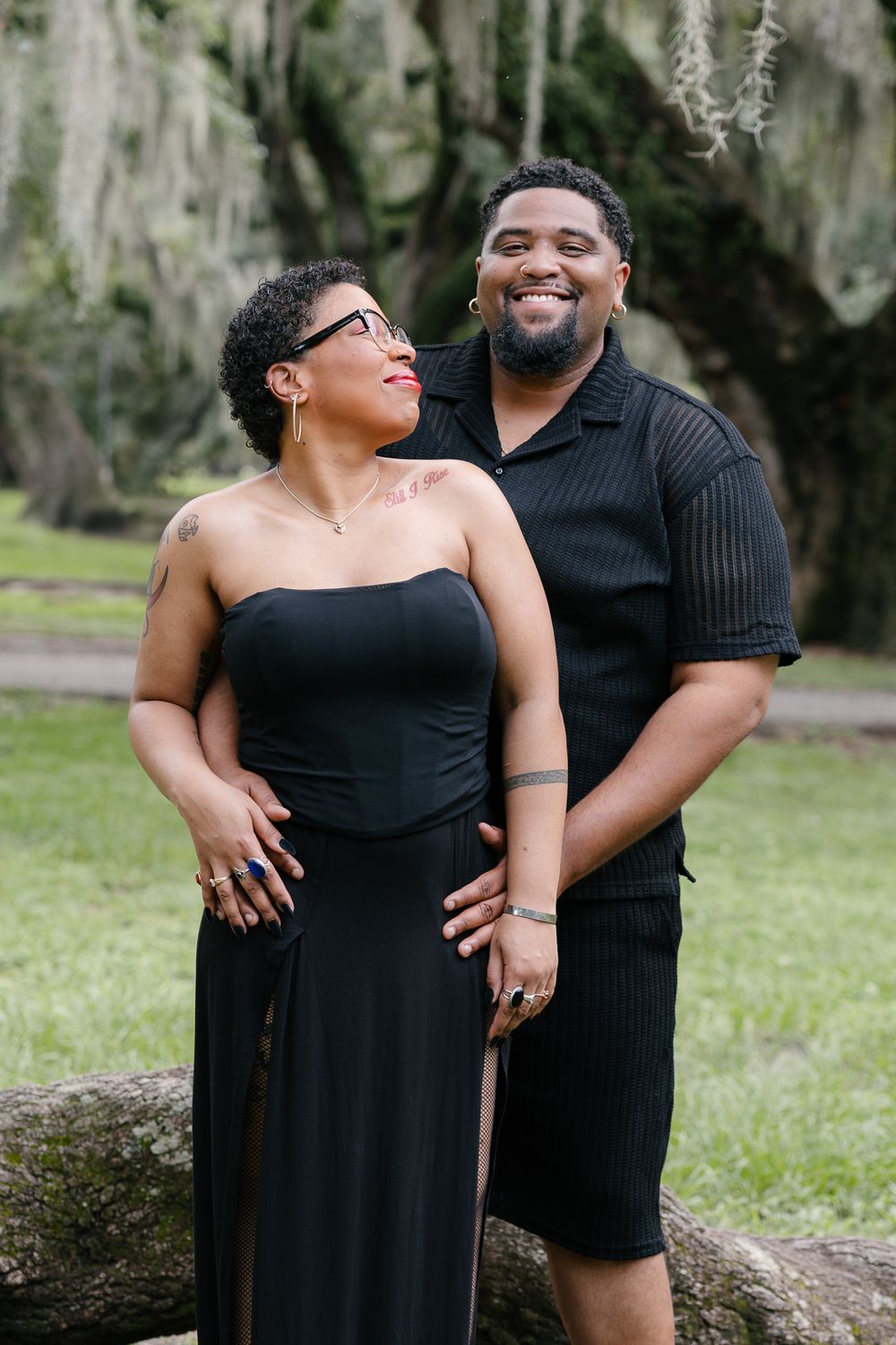 Candid outdoor portrait session in park with Spanish moss trees creating natural backdrop.
