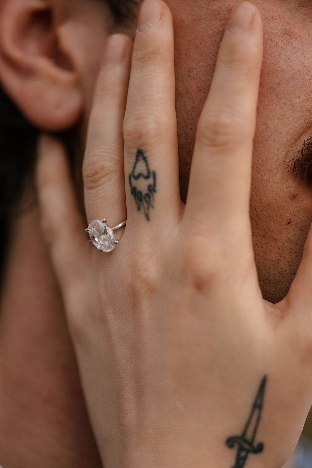 Close-up photos showing a hand wearing different rings, from small tattoos to a sparkling diamond engagement ring.