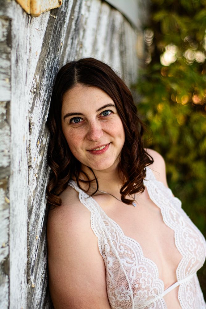 Intimate portrait against rustic white wood wall wearing delicate lace.