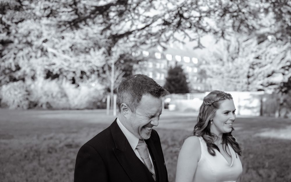 A black and white portrait of a wedding couple sharing an intimate moment outdoors.