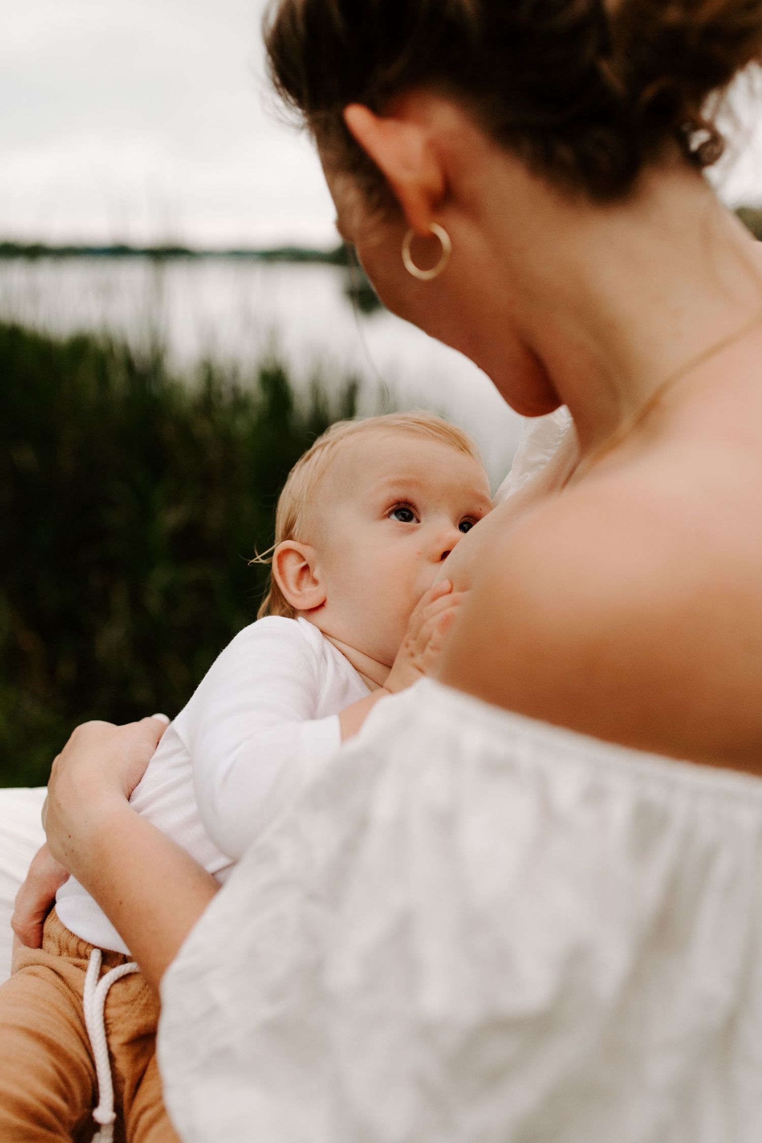 Young mom breastfeeding outside, family photos