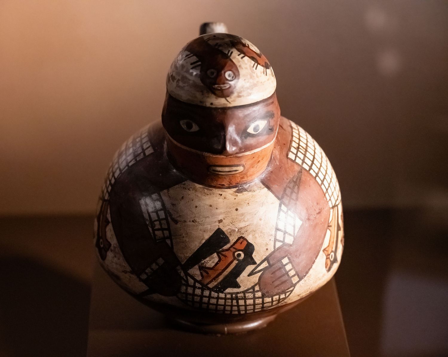Ancient ceramic vessel with geometric patterns and designs in black and earth tones.