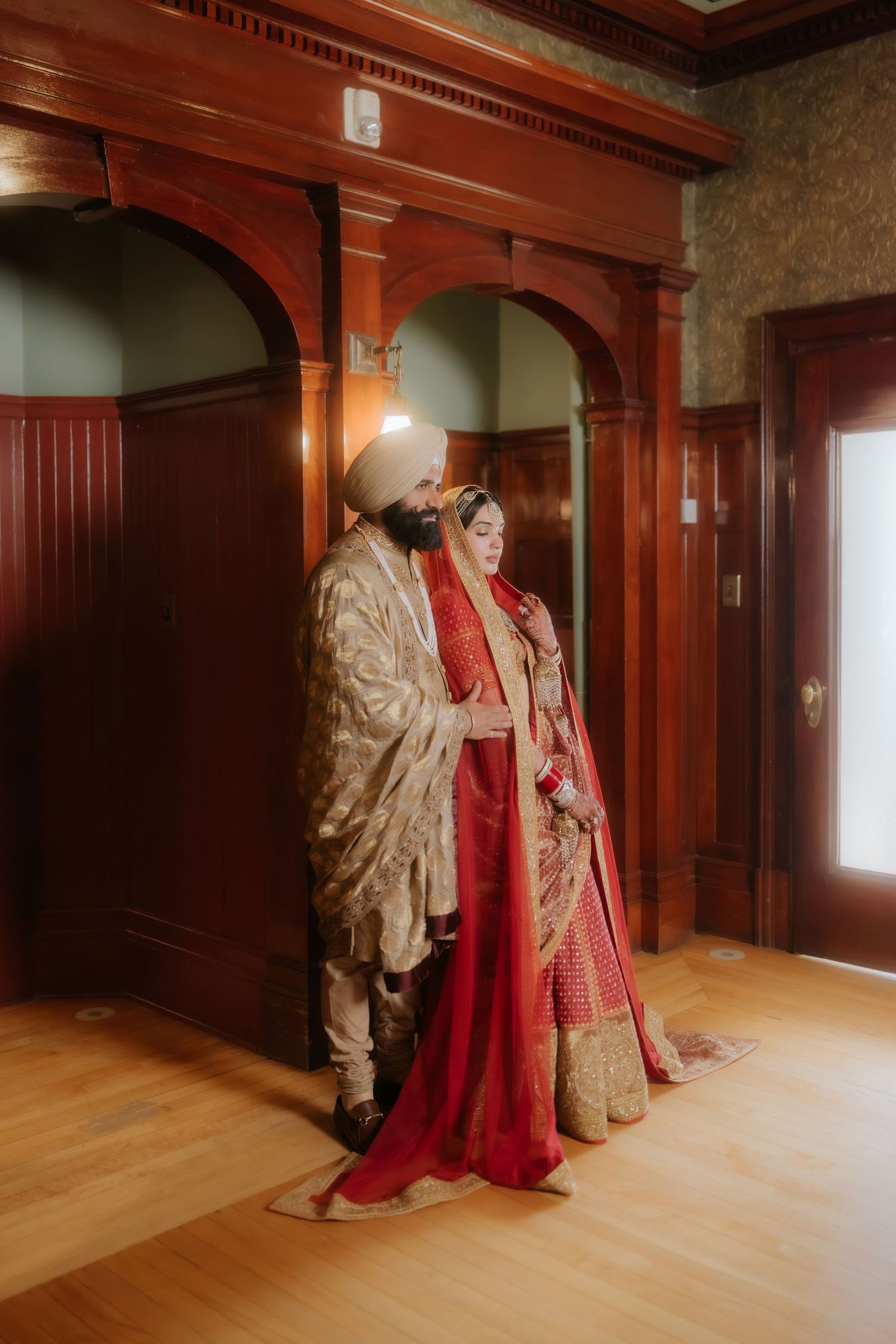 Traditional wedding ceremony with white-clad attendees and red floral decorations.