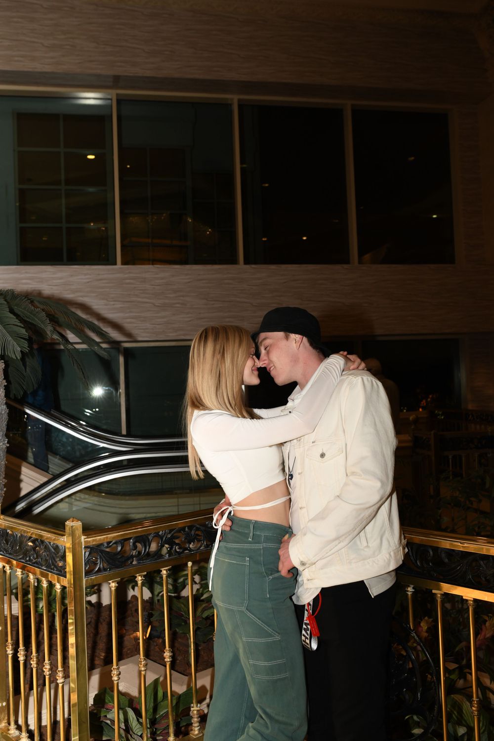 An intimate moment between a couple on a balcony with dim lighting.