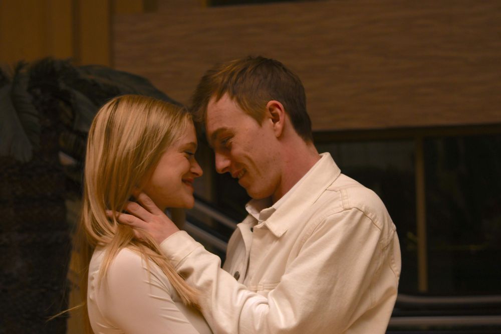 A tender moment between a couple in white and cream-colored clothing.
