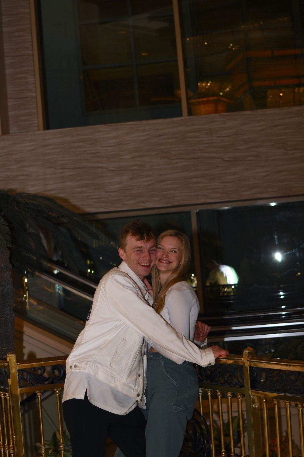 A happy couple in matching outfits sharing a candid moment on an evening balcony.