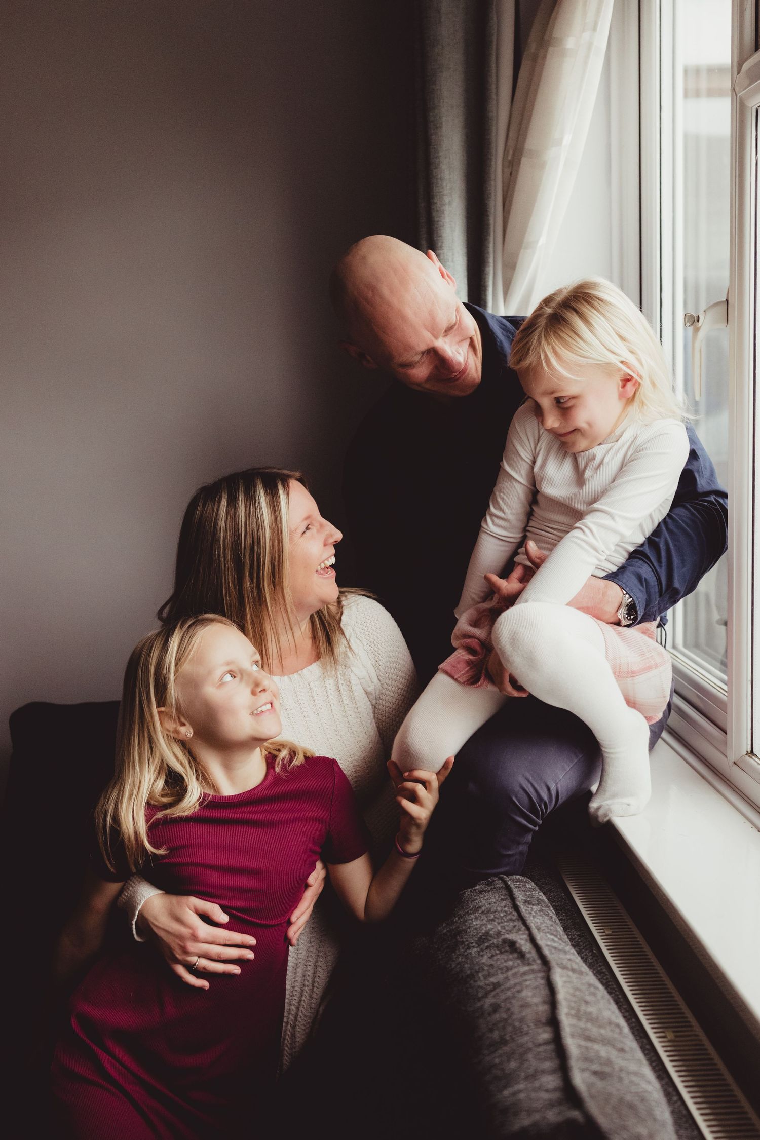 Tender moment shared between parent and child sitting on patterned rug in living room.