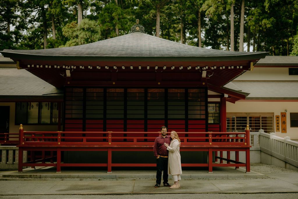 Couple standing in front of a traditional Japanese temple building.