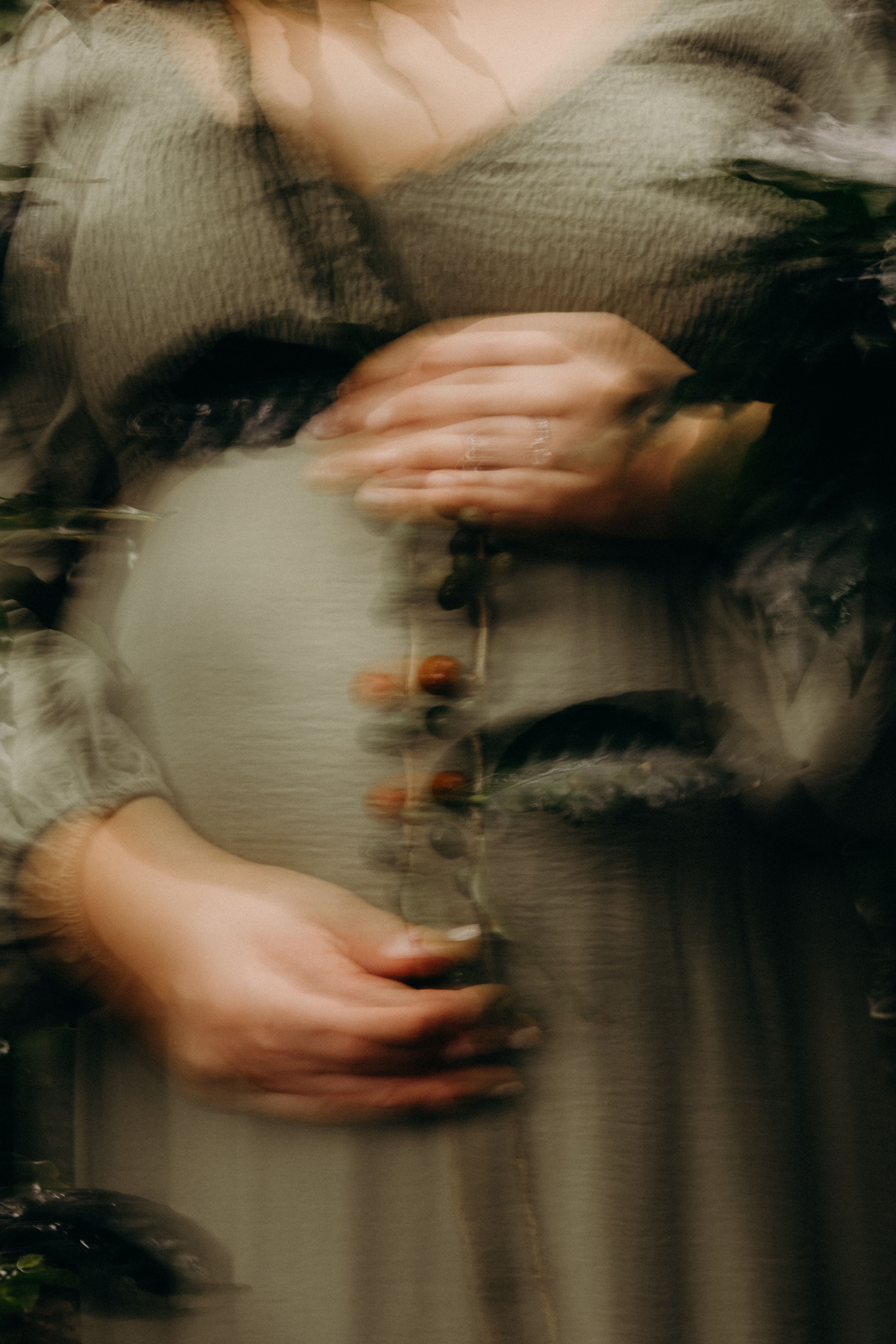 Blurred motion sequence of hands moving against a dark background creating an abstract artistic effect.