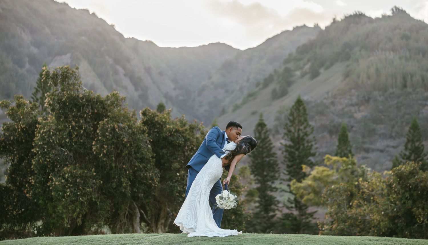 Dramatic mountain landscape serves as backdrop for romantic wedding portrait.