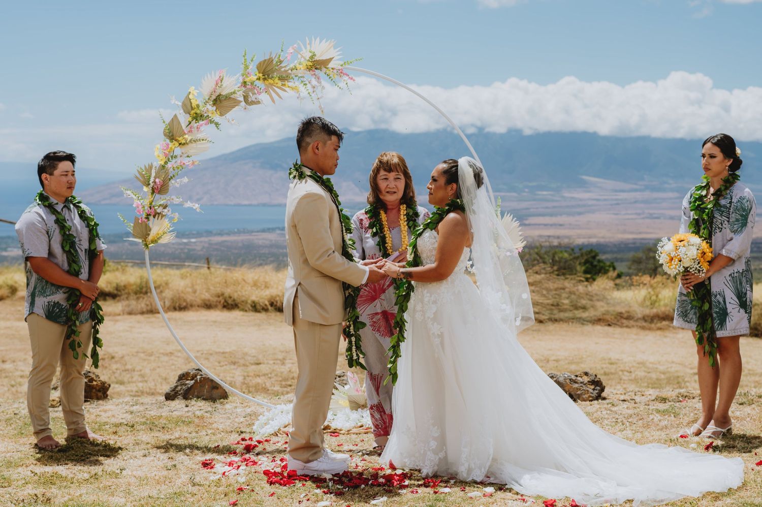 Desert wedding ceremony setup with mountain backdrop and floral arrangements.