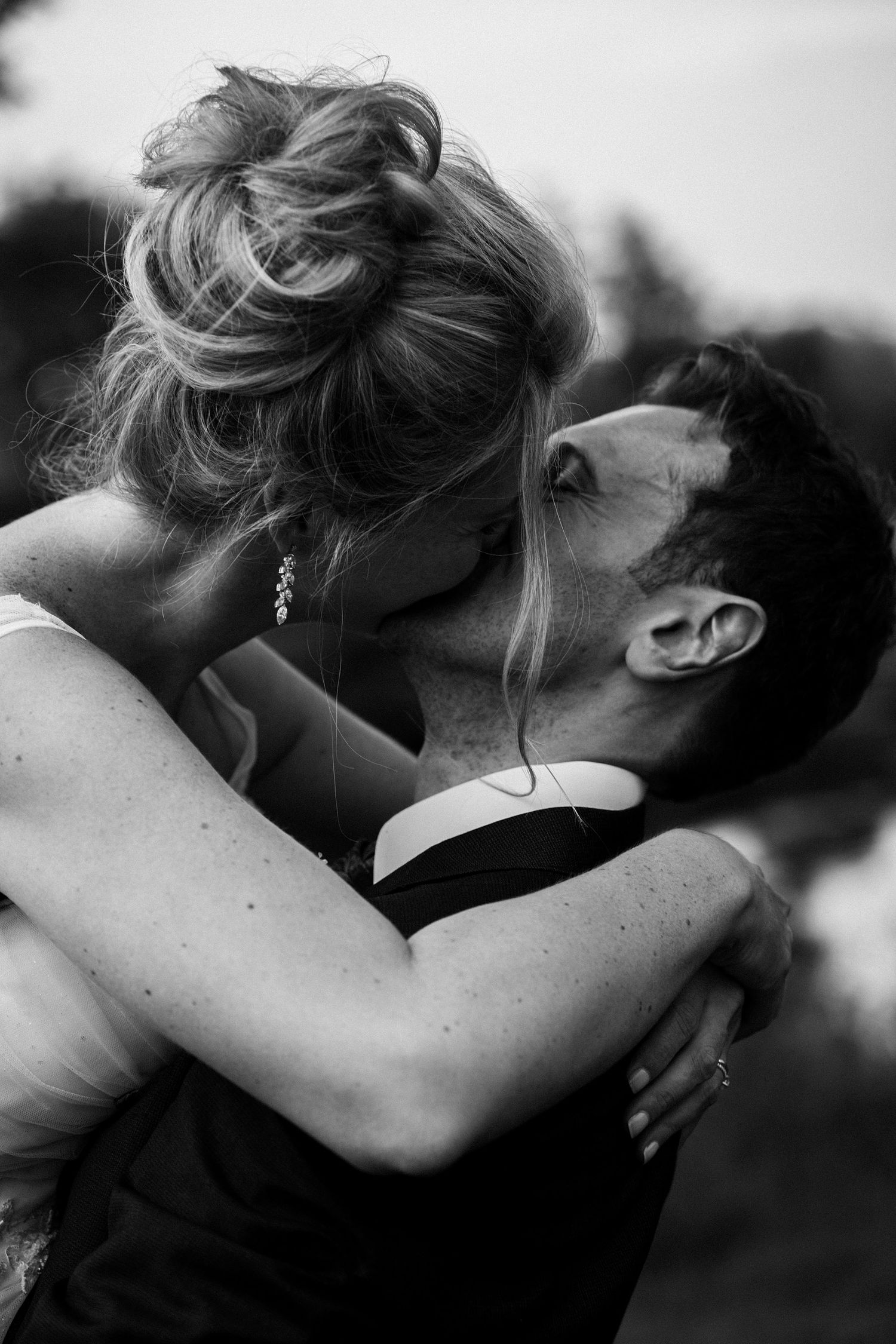 Black and white romantic photograph showing a couple embracing in an intimate moment.