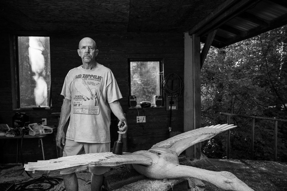 A series of black and white photos showing a craftsperson working on a traditional woodworking project in a rustic workshop.