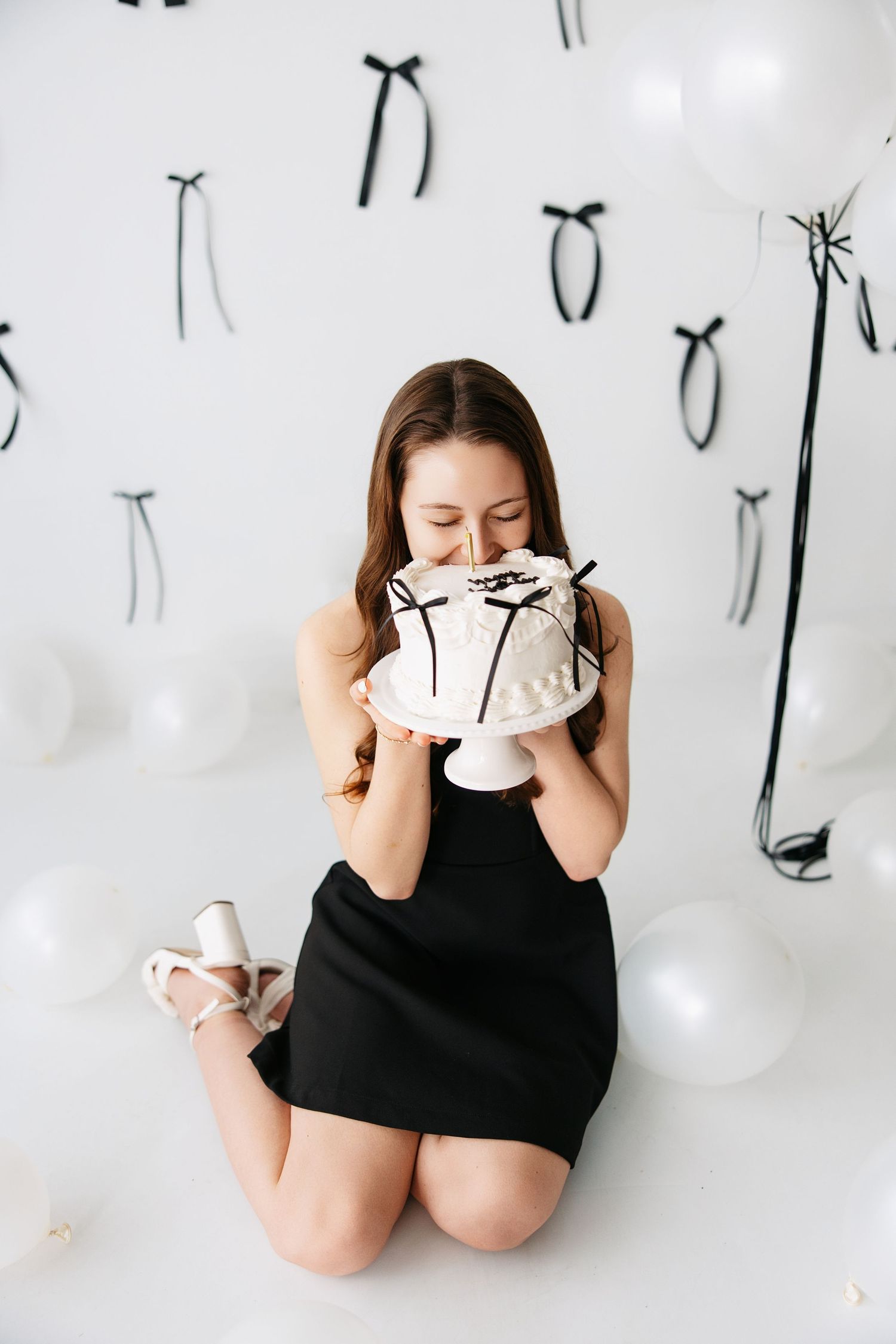 Four sequential photos show someone in black eating cake directly from a white plate in a playful manner.