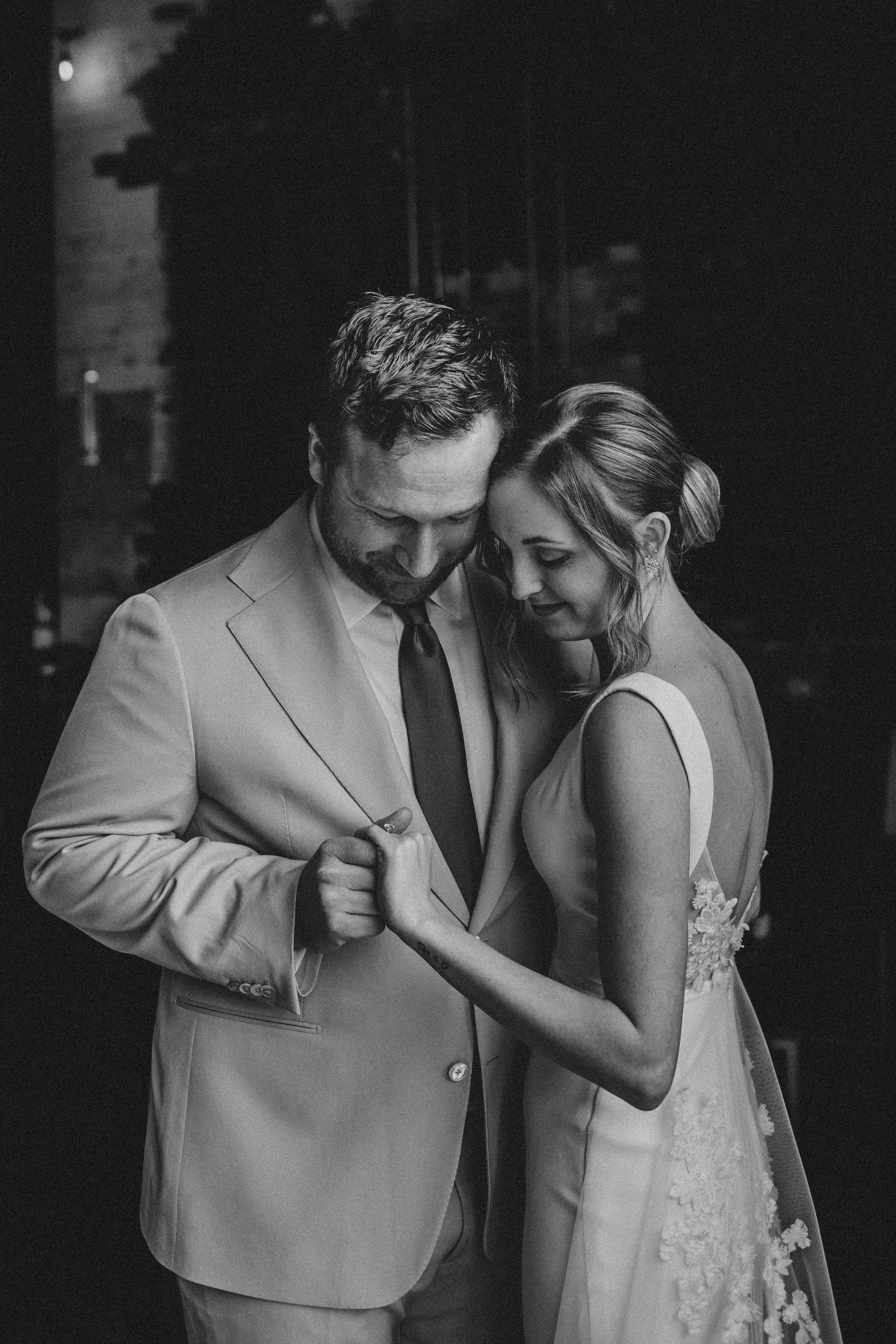 A romantic black and white photo series showing tender moments between a bride and groom on their wedding day.