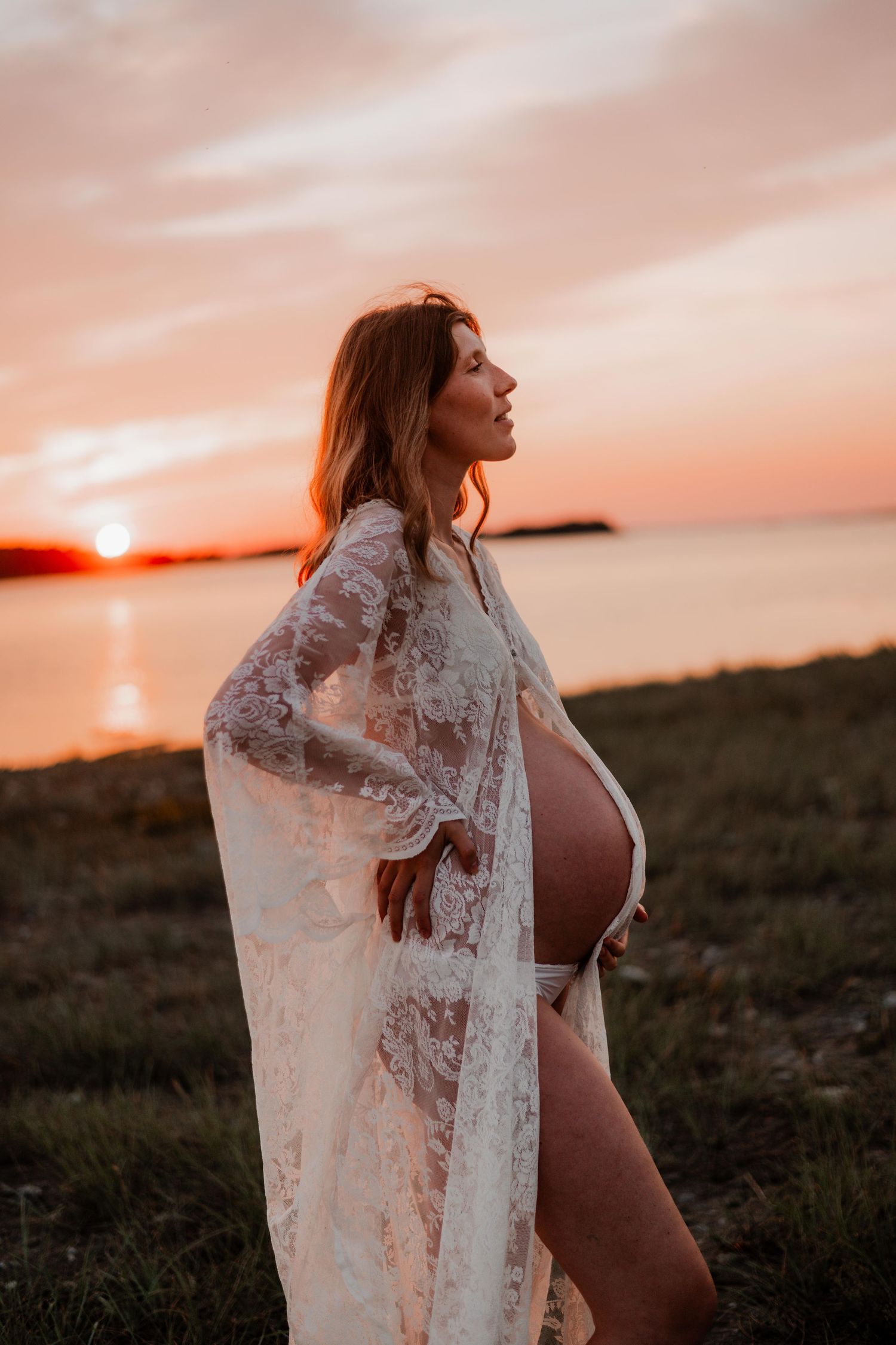 Gravid tjej i soledgången med bar mage och fin spetsklänning