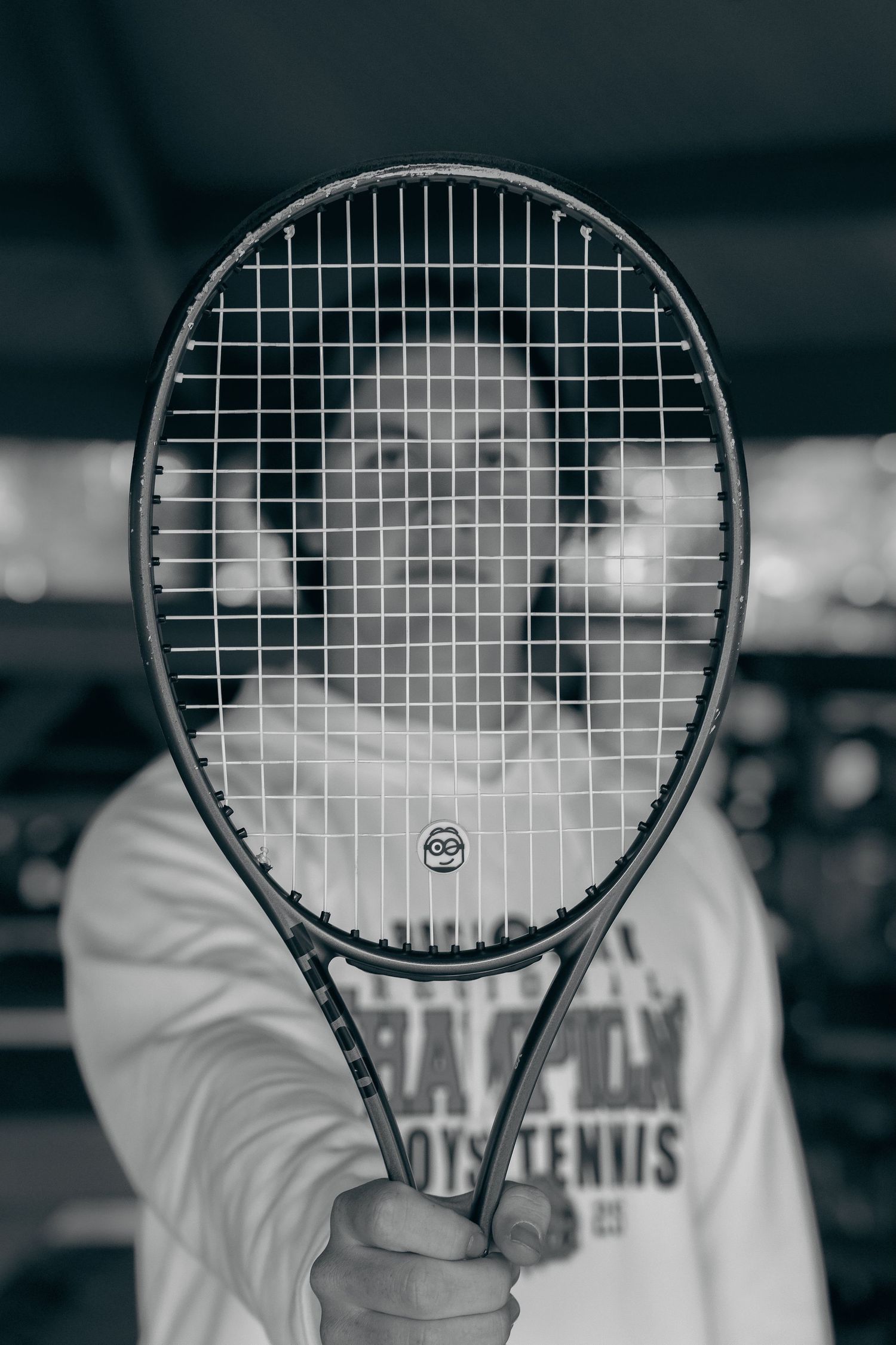 A series of black and white photos showing a tennis racket held at different angles against a blurred background.
