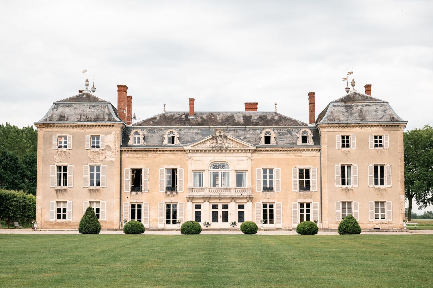 Elegant French chateau with symmetrical architecture and gray mansard roof spans across multiple connected images.