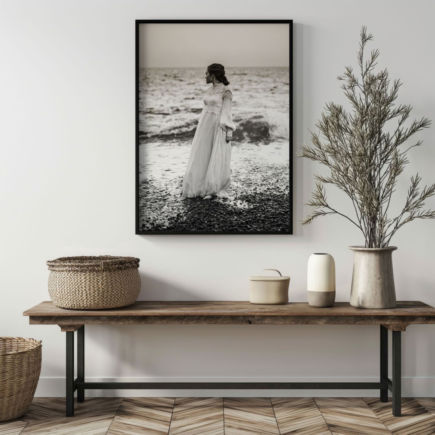 Modern minimalist interior design with black and white artwork, dried plants, and woven baskets on wooden shelving.