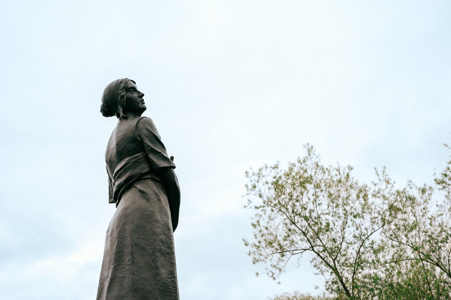 Fine art detail of a classical Evangeline statue in a wedding venue garden setting