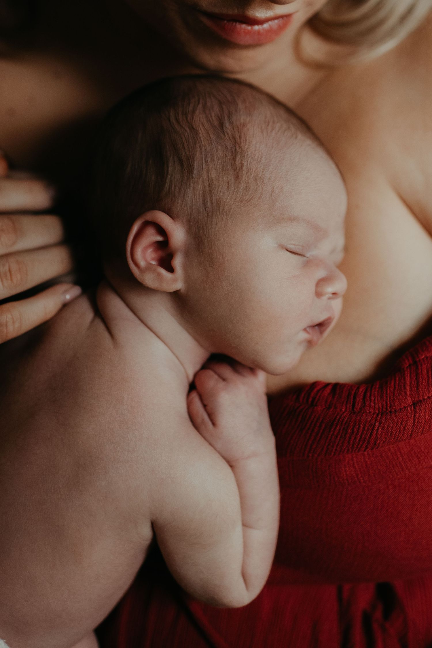 a new born baby lying on his mother's chest, while sleeping