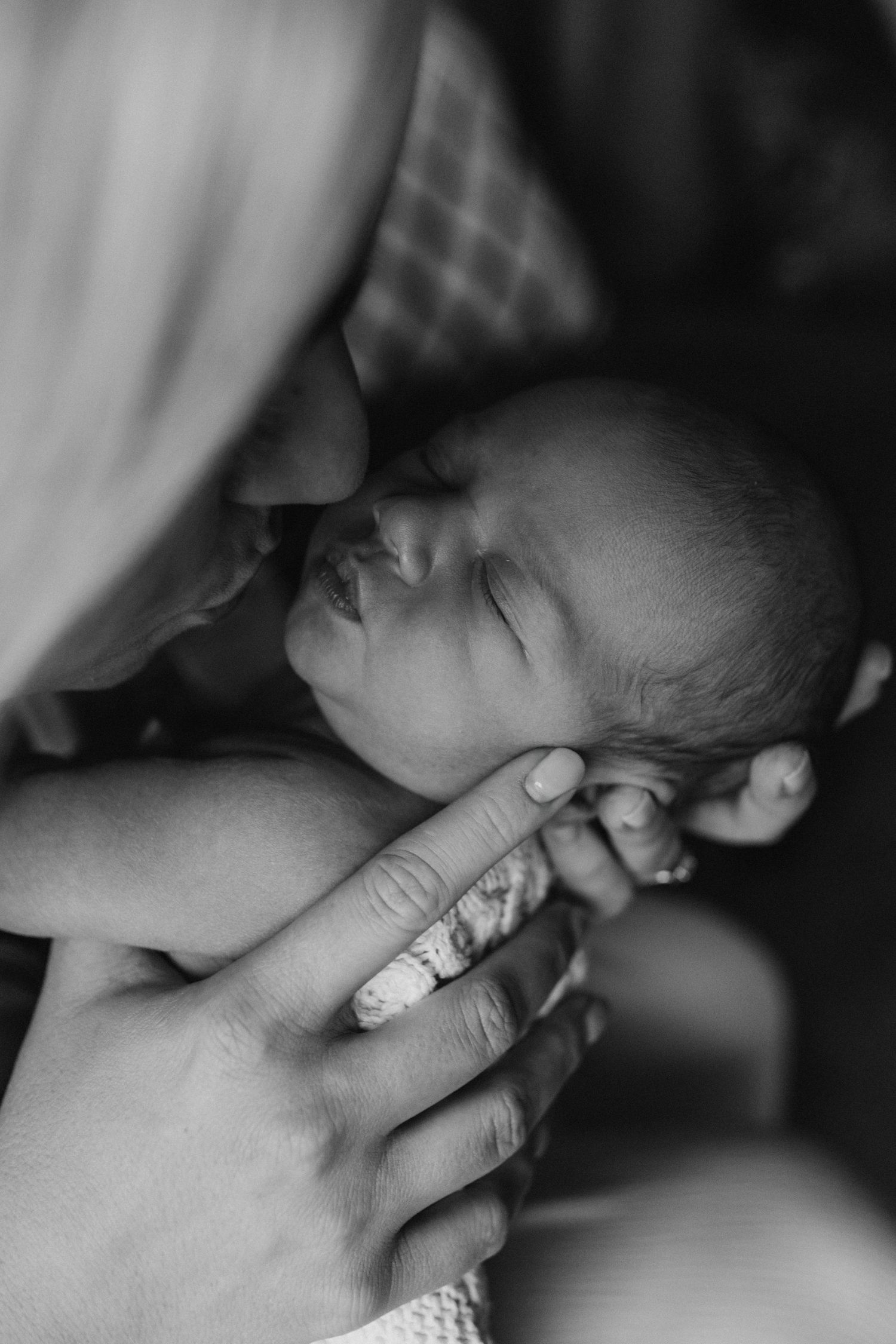 a mother holding her new born baby close to her face