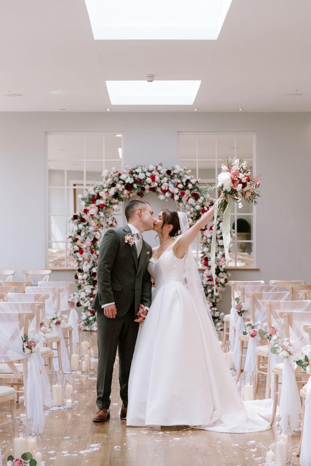 Elegant wedding ceremony setup ar Bredenbury Court Barns with floral arch and rose petal-lined aisle for intimate celebration.