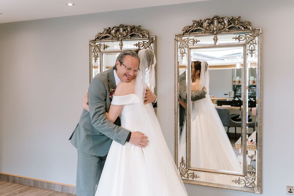 A series of wedding photos showing emotional first look moments between a bride and her father in an elegant indoor setting.