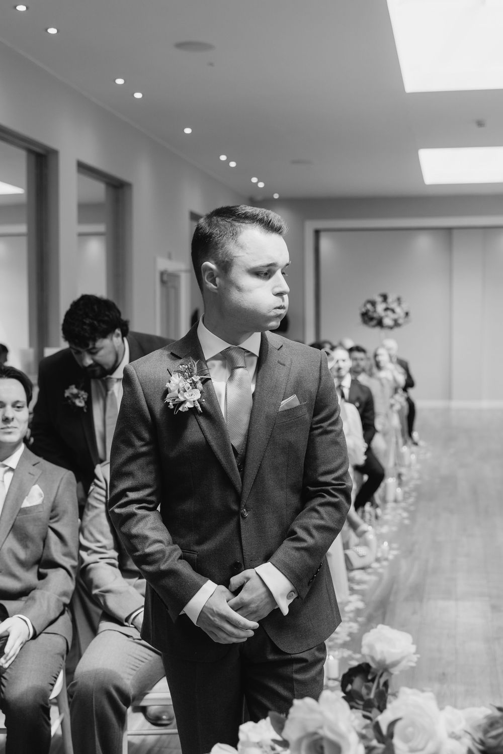 Worcestershire Wedding party members in dark suits stand in a row during an indoor ceremony.