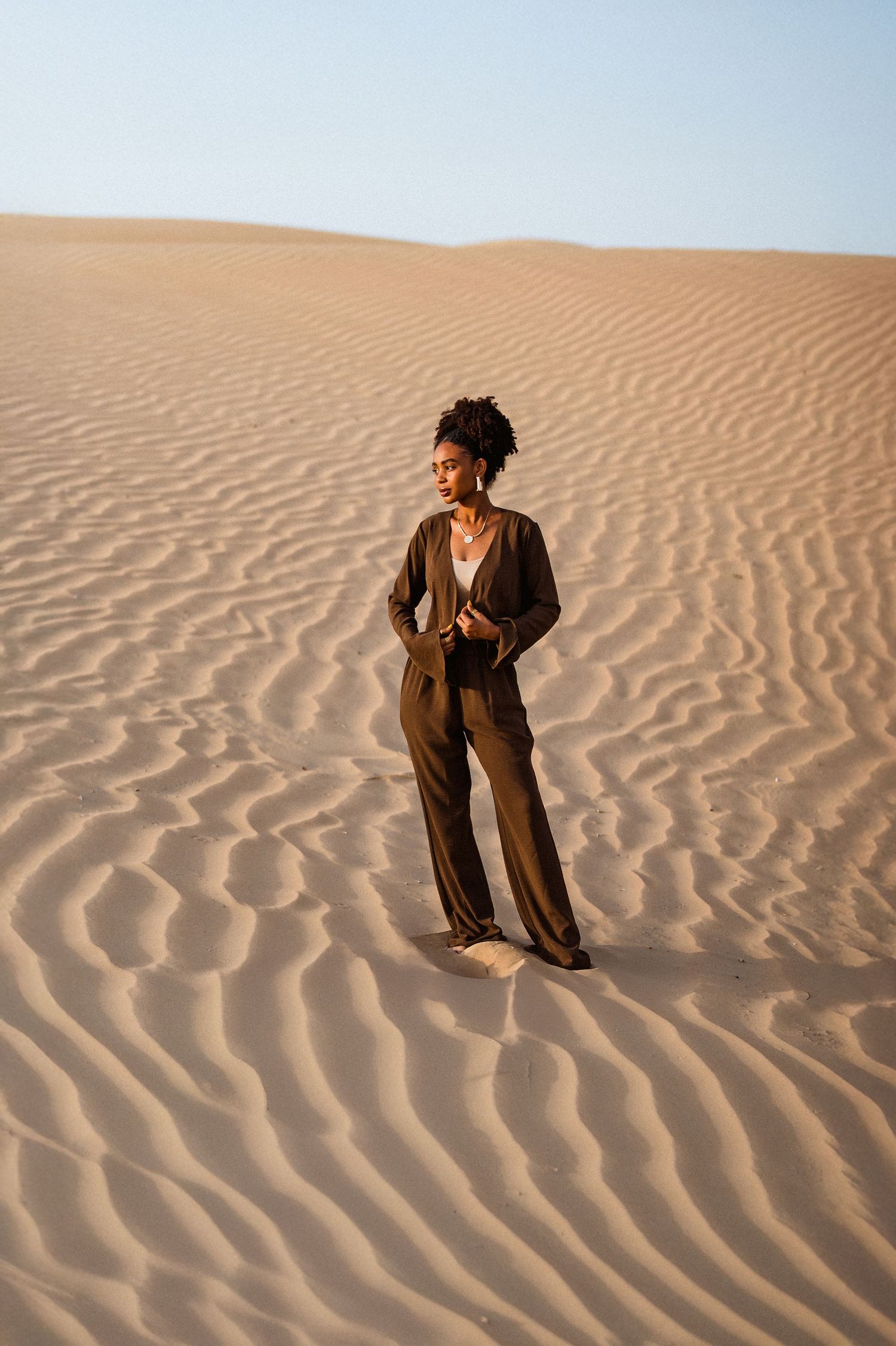 Editorial fashion photography in Dubai desert featuring model on sand dunes