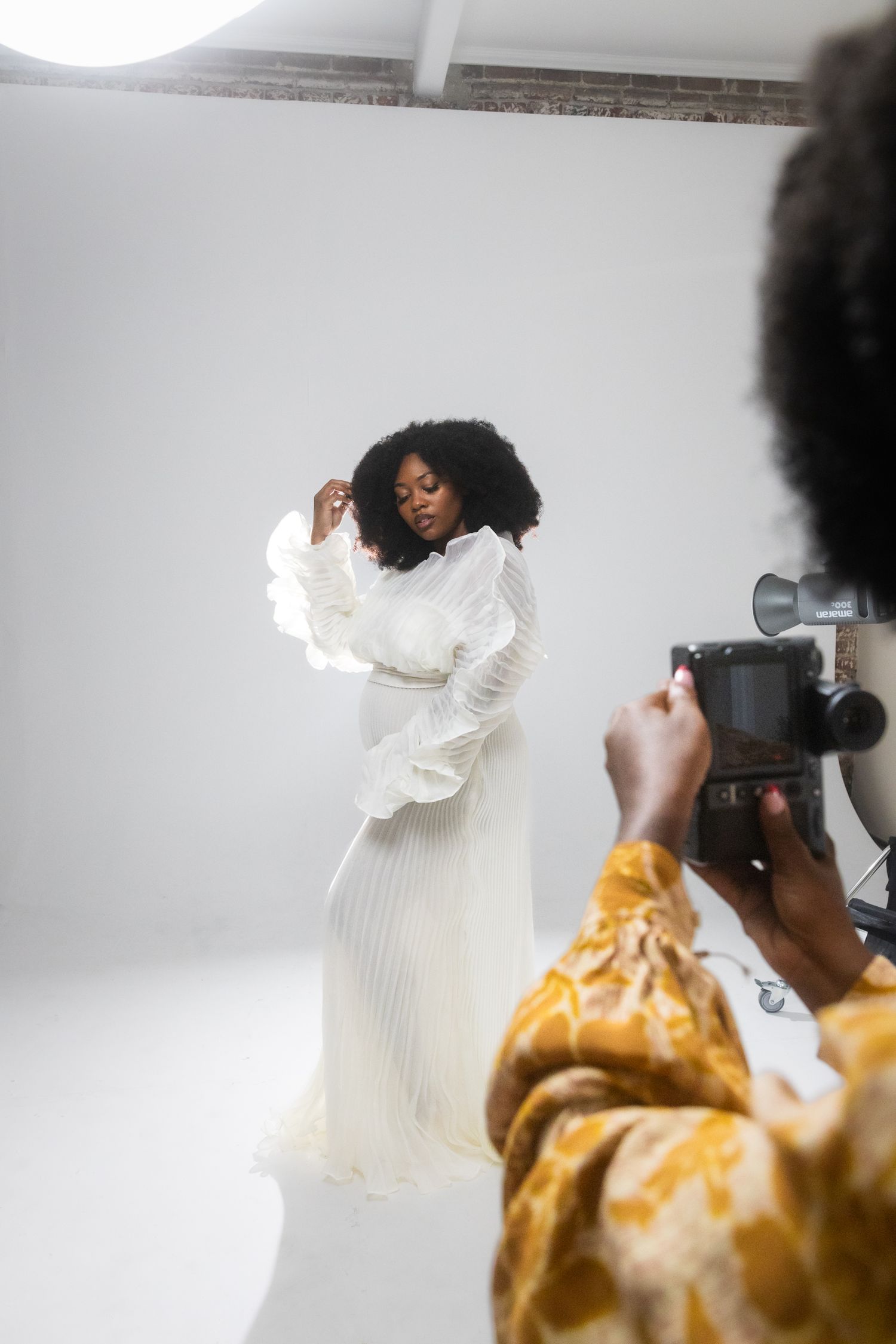 A series of fashion photos showing a model in a white ruffled dress and yellow floral dress against a light background.