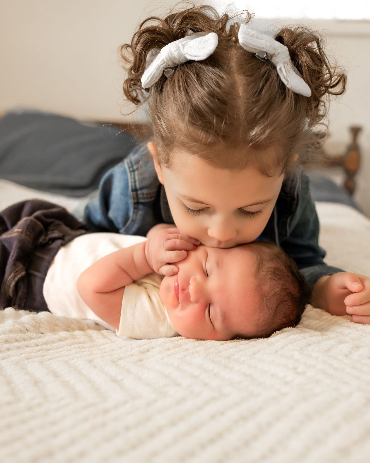 A series of tender moments showing a toddler giving gentle kisses on a textured white surface.