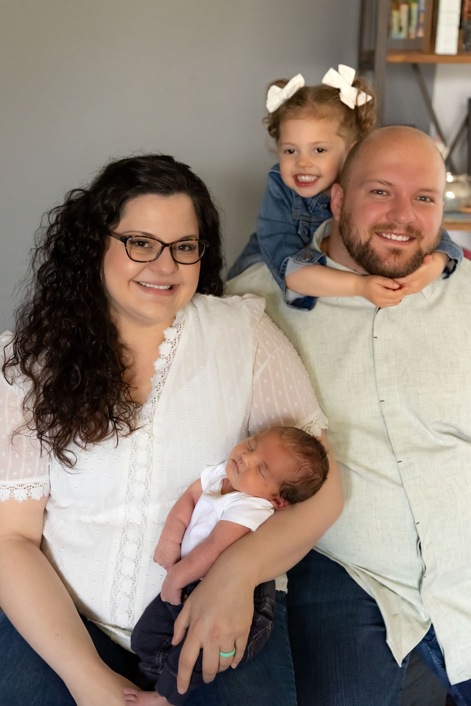 A series of five family photos showing tender moments with a newborn baby in white clothing.