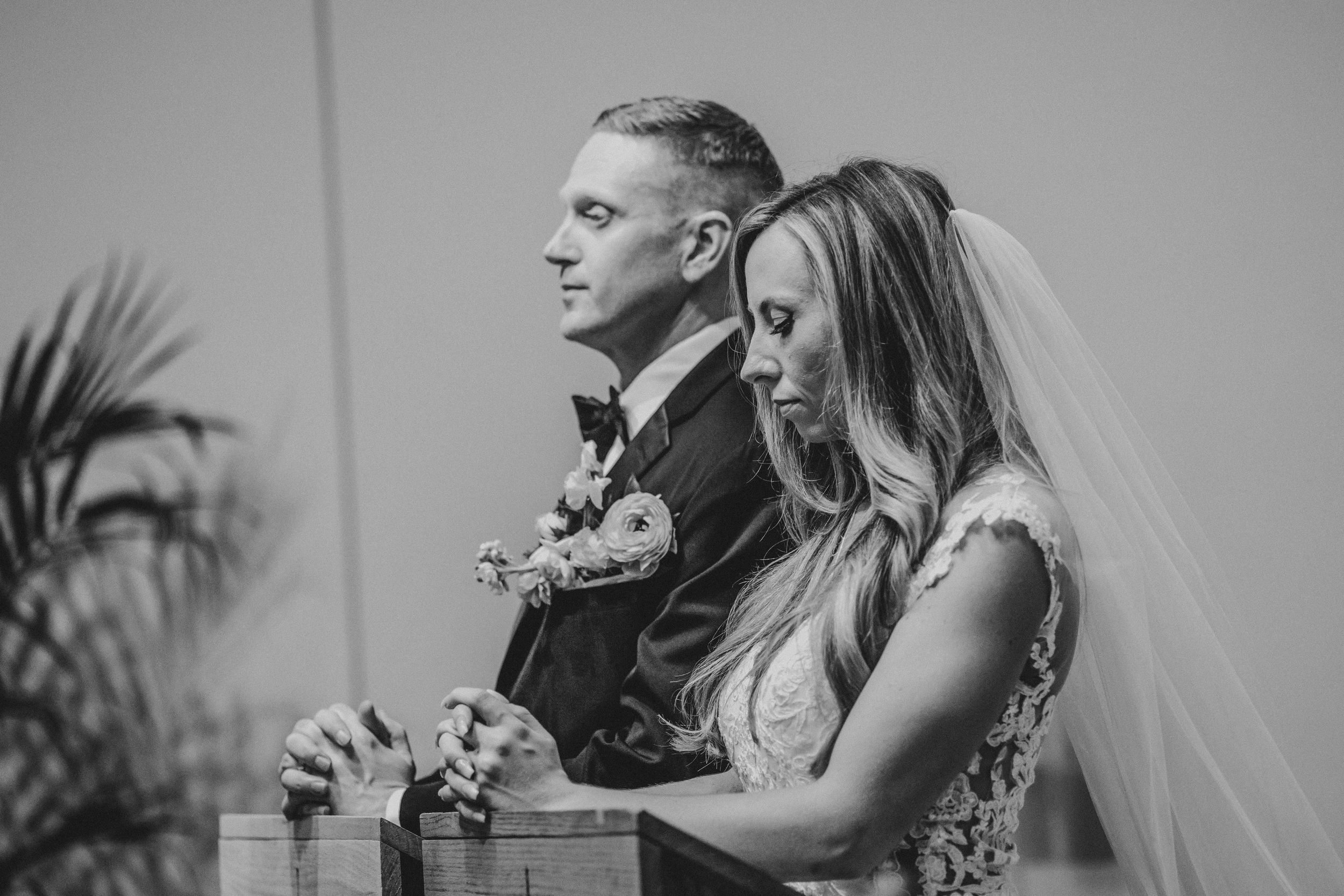 Black and white wedding photos showing couples during emotional moments at their ceremony and reception.