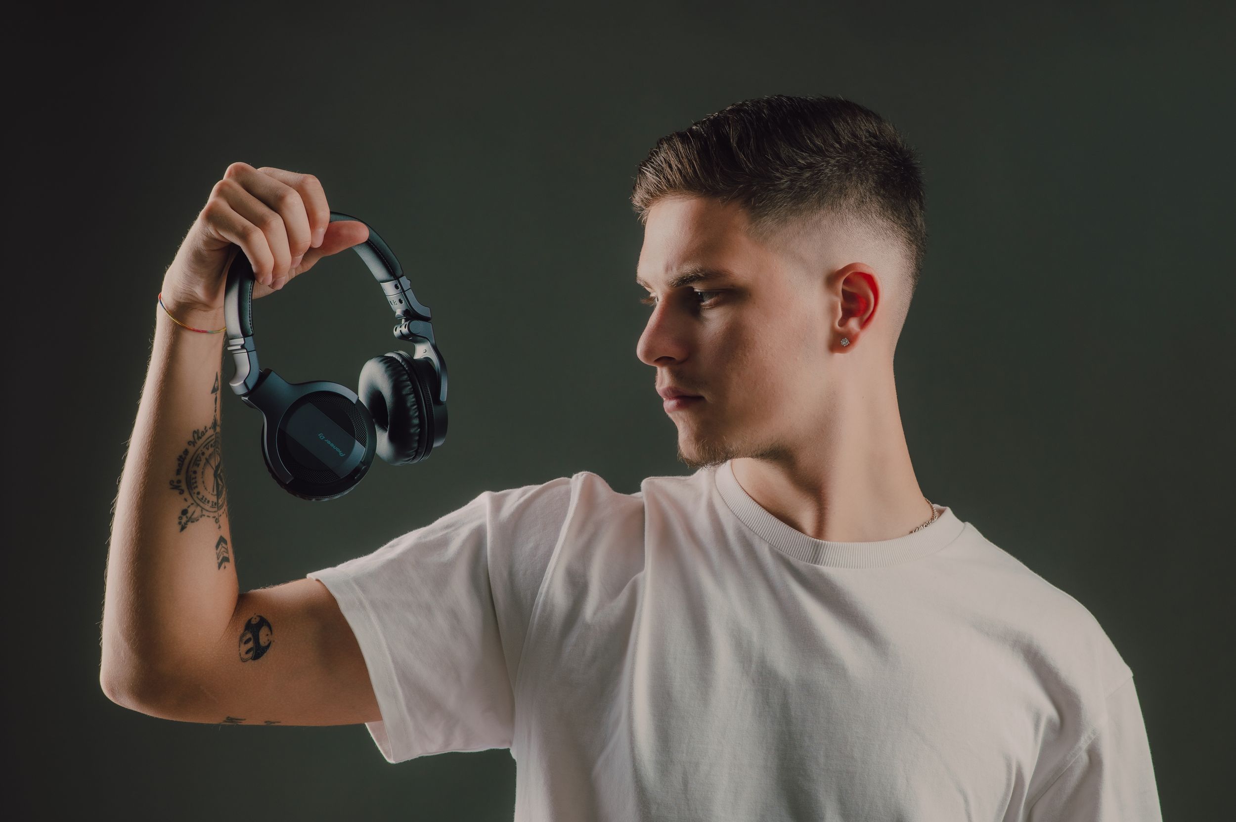 Man in white t-shirt performs bicep curls with dumbbells against dark background in sequence of workout photos.