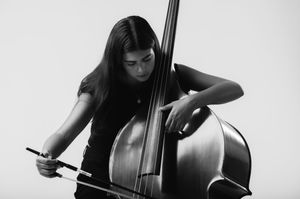Musician plays a double bass in black and white, creating a moody artistic composition.